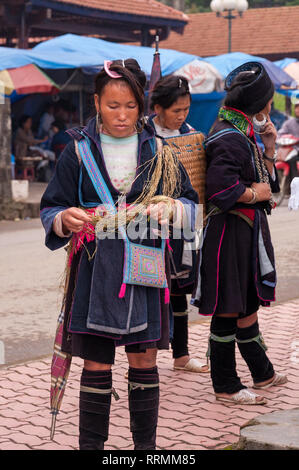 Eine lokale Hmong Frau in traditioneller Kleidung steht weben Seil, Sa Pa, Vietnam Stockfoto