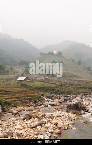 Terrassierten Hügeln und landwirtschaftlichen Häuser in Nebel mit Fluss im Vordergrund, Sa Pa, Vietnam Stockfoto