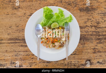 Blick von oben auf die Thai gebratene Nudeln "Pad Thai" mit Gemüse auf einem Holztisch. Stockfoto