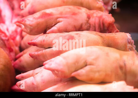 Schweinefleisch Füße auf der Anzeige für den Verkauf am lokalen Markt. Stapel von rohem Schwein geschlachtet Beine Stockfoto