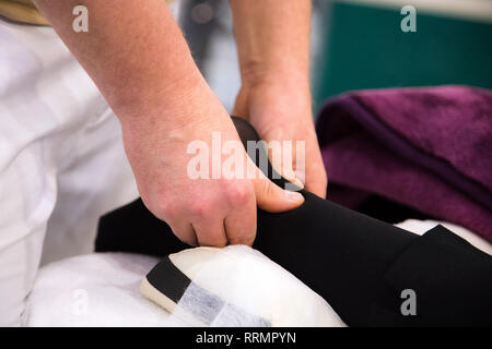Osteopathie. Frauen, die ein Bein- und Fußmassage beim liegen auf einem Handtuch in der Gesundheit Massage Center Stockfoto