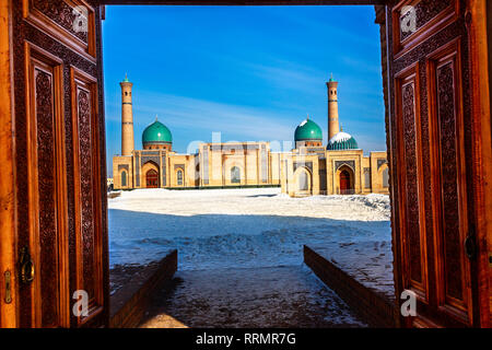 Winter geschossen von blauen Kuppeln, Moscheen und Minarette von hazrati Imam medrese mit Holz verzierte Türen im Vordergrund, das religiöse Zentrum von Taschkent, Uzb Stockfoto