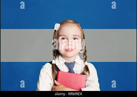 Argentinien Konzept mit kleinen Mädchen mit Buch gegen die argentinische Flagge Hintergrund Stockfoto