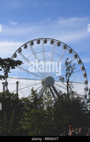 Amusement Park Rad mit Bäumen im Vordergrund. Vergnügungspark Divo-Insel. Sankt Petersburg.