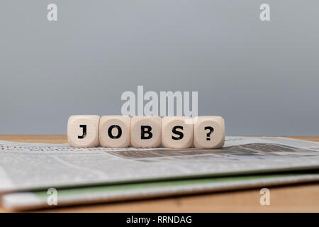 Würfel form Jobs das Wort ' ' mit einem Fragezeichen auf eine Zeitung. Stockfoto