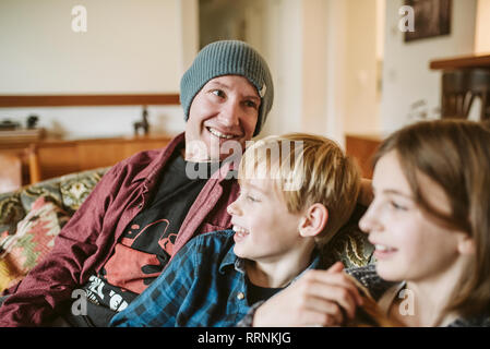 Vater und Kinder entspannen auf Sofa im Wohnzimmer Stockfoto