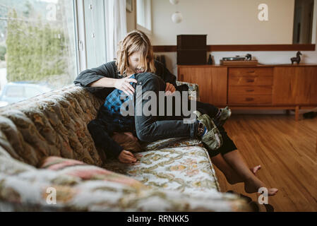 Verspielte Mutter und Sohn auf Sofa im Wohnzimmer Stockfoto