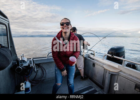 Portrait begeisterte Frau auf Fischerboot Stockfoto