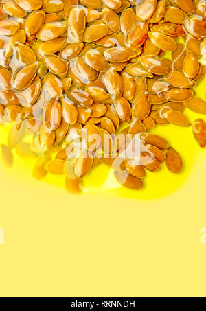 Leinsamen oder Leinsamen im Olivenöl auf gelben Hintergrund. Mehrfach ungesättigte Fettsäuren Omega 3-6-9 Vitamin. Stockfoto