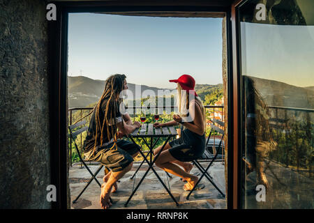 Paar entspannende, trinken Wein auf sonnigen Balkon Stockfoto