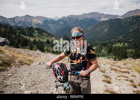 Portrait Active Senior mann Mountainbiken in abgelegenen Landschaft, Chilcotin Mountains, British Columbia, Kanada Stockfoto