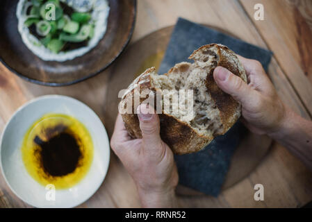 Persönliche Perspektive Hände brechen Brot Stockfoto