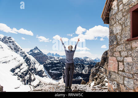 Üppige weibliche Wanderer auf sonnigen, verschneiten Berggipfel, Yoho Park, British Columbia, Kanada Stockfoto