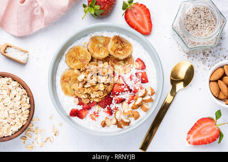 Superfood Smoothie Schüssel mit Banane, Chia Samen, Erdbeere, Mandeln und Müsli. Gesunde Snacks, Frühstück, vegane Mahlzeit. Konzept der Gewichtsverlust, dietin Stockfoto