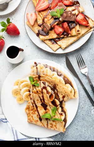 Pfannkuchen mit Schokolade, Banane und Erdbeere. Ansicht von oben. Köstliche Europäische oder Französisches Frühstück, Ansicht von oben Stockfoto