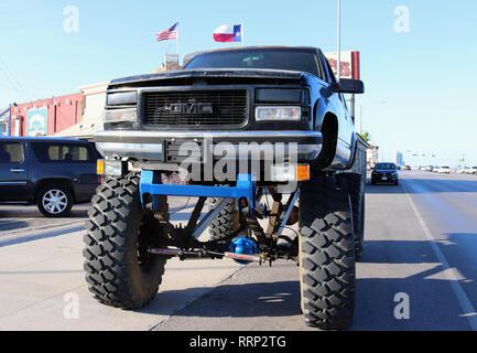 GALVESTON, Texas, USA - Juni 9, 2018: Typisch texanische Straße Landschaft. Ein riesiges Monster Truck ist auf dem Boulevard geparkt. Im Hintergrund US-Flaggen. Stockfoto