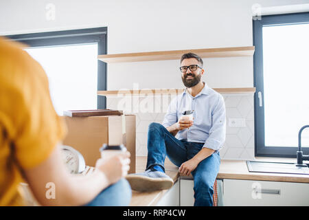 Ein junges glückliches Paar Kaffee trinken bei der Einrichtung neues Haus, ein Umzug in neue Home Konzept. Stockfoto