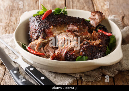 Pernil asado langsam gekocht geschreddert zog Schweinefleisch close-up auf einem Teller auf den Tisch. Horizontale Stockfoto