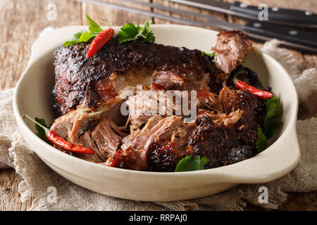 Köstlich würzigen langsam zerfetzt zog Schweinefleisch closeup auf einem Teller auf den Tisch. Horizontale Stockfoto