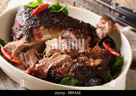 American Food Pernil Asado zerkleinertem Schweinefleisch closeup auf einem Teller auf dem Tisch gezogen. Horizontale Stockfoto