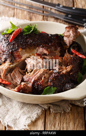 Die nationalen Lateinamerikanischen Gericht aus Pernil Asado zerkleinertem Schweinefleisch closeup auf einem Teller auf den Tisch. Vertikale Stockfoto