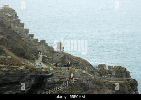 Touristen erkunden Sie die Ruinen der Burg Tintagel an einem trüben Tag. Stockfoto