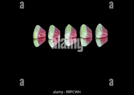Obst Gummibärchen der Wassermelone isoliert auf einen Spiegel mit dunklen Hintergrund Stockfoto