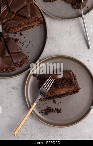 Close up geschnittene Schokolade Kuchen in Platten auf grauem Beton Hintergrund, Ansicht von oben Stockfoto