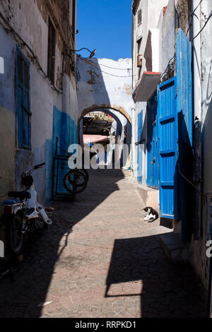 Schmale Straße für Fußgänger, Fahrräder und Karten. Weiße Wände, helle blaue Details, der mit der Farbe des Himmels. Altstadt (Medina), Marokko. Stockfoto