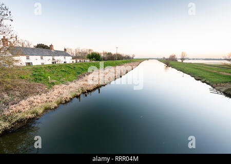 Sutton Gault, Cambridgeshire UK. 26. Februar 2019. Die New Bedford River ist komplett noch auf einer windstillen Abend nach einem ungewöhnlich warmen Tag im Februar, wo Temperaturen erreicht die hohen Teens Celsius über viel von Großbritannien. Die flache, freiliegenden Moorlandzone Landschaft in der Regel windig und kalt diese Zeit des Jahres werden aber die Unseasonal warmes Wetter hat zu einem ruhigen Abend geführt. Credit: Julian Eales/Alamy leben Nachrichten Stockfoto