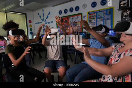 Junior high school Kursteilnehmer mit Virtual Reality Simulatoren im Klassenzimmer Stockfoto