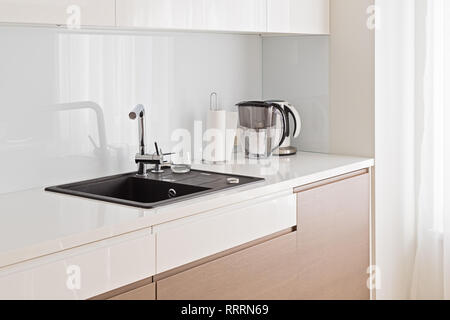 Blick auf moderne, geräumige und helle Küche mit dunklen Waschbecken und beige Schrank mit Platz kopieren Stockfoto