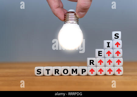 Symbol für steigende Strompreise. Würfel Form des deutschen Wort trompreis' ('Strom rate" in Englisch vor einer Glühbirne). Stockfoto