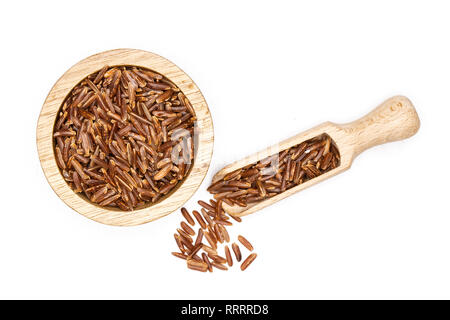 Menge ganze rohe rote Reis in eine Schaufel mit Houten flatlay auf weißem Hintergrund Stockfoto