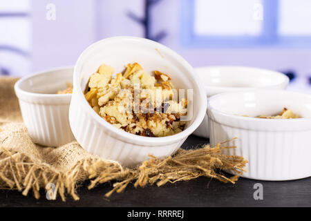 Letzte Schritt. Rezept Schritt für Schritt mit Früchten in einem keramischen ramekin mit blauen Fenster im Hintergrund bröckeln Stockfoto