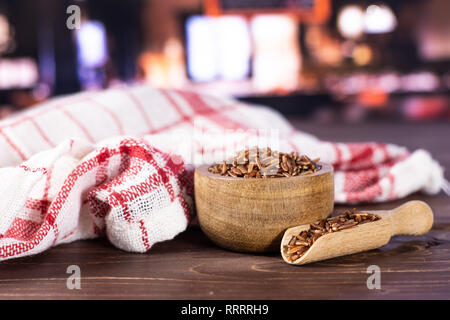 Menge ganze rohe rote Reis Geschirrtuch mit Holzschale mit Restaurant im Hintergrund Stockfoto