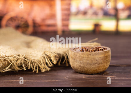 Menge ganze rohe rote Reis Jute-stoff mit Holzschale mit Karre im Hintergrund Stockfoto