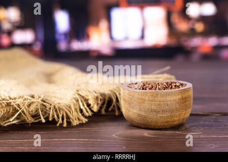 Menge ganze rohe rote Reis Jute-stoff mit Holzschale mit Restaurant im Hintergrund Stockfoto