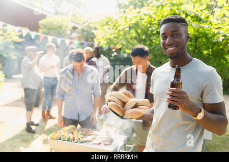 Portrait selbstbewussten jungen Mann trinkt Bier, genießen Barbecue im Sommer Hinterhof Stockfoto