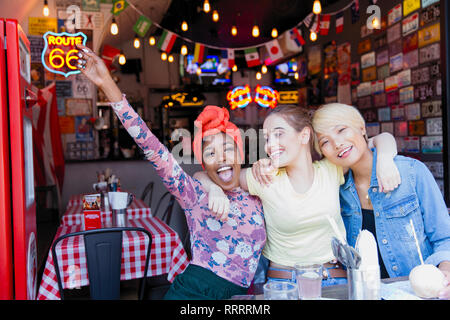 Portrait ausgelassenen jungen Frauen, die Freunde an der Bar Stockfoto