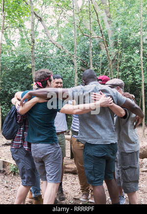 Mens Gruppe umarmt in Unordnung, Wandern im Wald Stockfoto