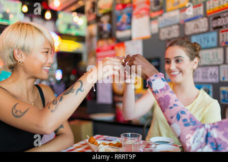 Junge Frauen, die Freunde von Alkohol Schüsse in bar Stockfoto
