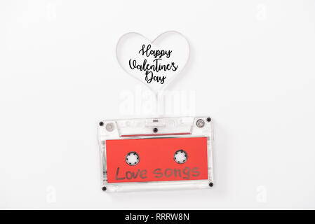 Blick von oben auf die audiokassette mit 'Love Songs' Schriftzug und das Herzsymbol auf Weiß mit "Happy Valentines Day" isoliert Schriftzug Stockfoto