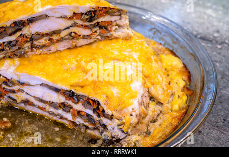 In einem Glas Backblech im Ofen gebacken, ein geschichtetes Fleisch Torte mit Pilzen und Gemüse, mit geschmolzenem Käse bedeckt, bereit zu essen, in Stücke geschnitten Stockfoto