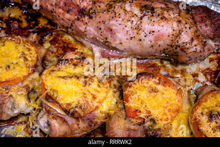 Appetitliche leckere Kalorienarme Diät juicy Hähnchenschenkel gewürzt mit Tomate und bestreut mit geriebenem Käse überbacken im Ofen braten im eigenen Saft Stockfoto