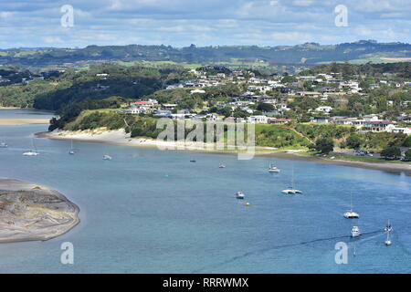 Blick auf den Hafen Mangawhai mit Liegeplätzen und Sanddünen und dichten Gehäuse der beliebten Ferienort Mangawhai Heads. Stockfoto