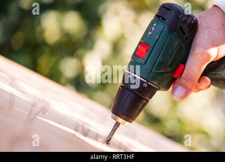 Tischler Bohrer ein Loch mit einer elektrischen Bohrmaschine Stockfoto