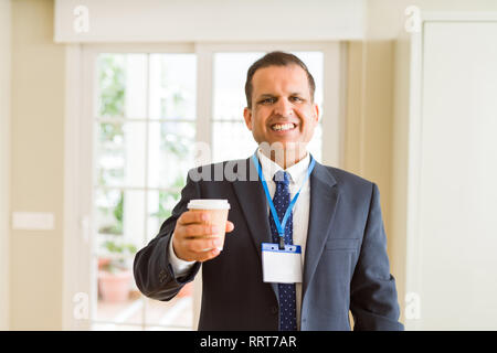 Mittleres Alter Geschäftsmann, trinken eine Tasse Kaffee tragen ID-Karte Stockfoto