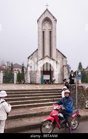 Nhà Thờ Đá Sapa oder die Kathedrale Notre Dame mit lokalen Vietnamesischen außerhalb an einem bewölkten Tag, Sa Pa, Vietnam Stockfoto