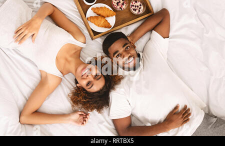 African-american Paar beim gesunden Frühstück im Bett Stockfoto